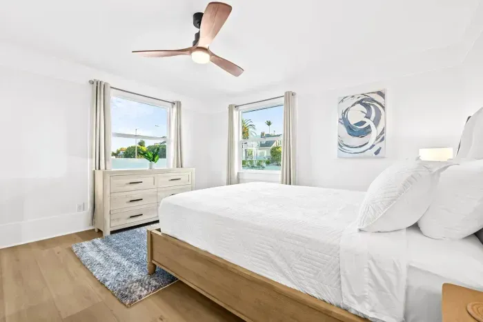 Sunny bedroom with soft bedding and warm light.