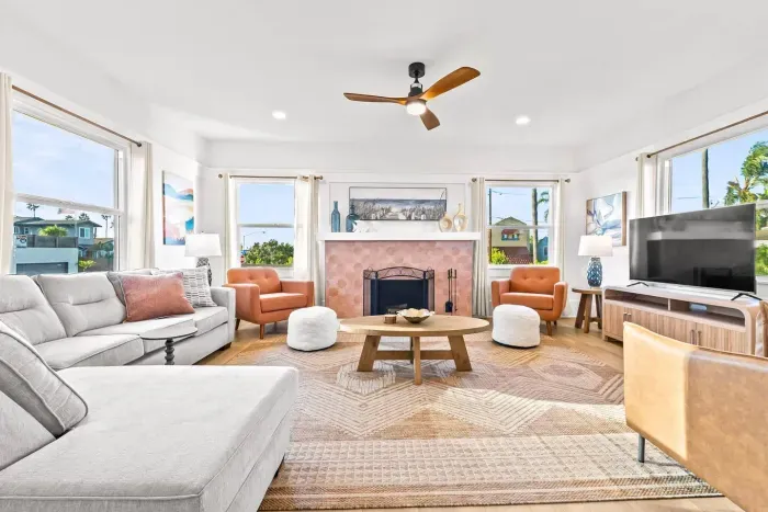 Spacious living room with large windows and a classic fireplace.