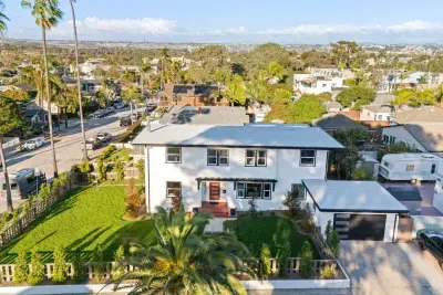 Aerial view of the home with a large yard and bright two-story exterior.