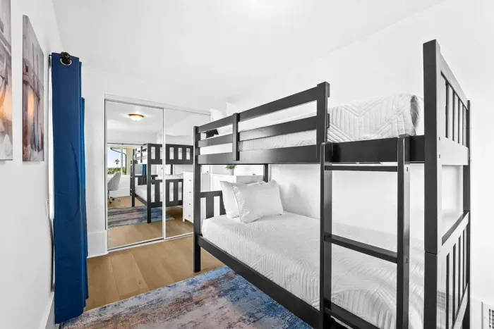 Bunk beds with mirrored closet and bright decor.