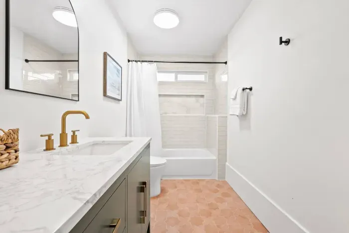 Clean bathroom with tub and gold accents.