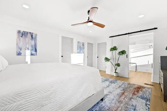 Spacious bedroom with seating and large windows.