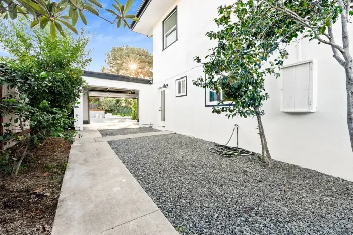 Side walkway with fresh landscaping and clean pathways.