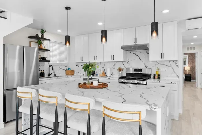 Sleek chef’s kitchen with quartz island, gas range & seating for four