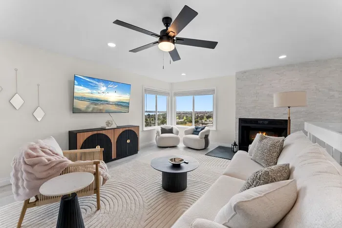 Bright living room with fireplace, corner views, and chic seating