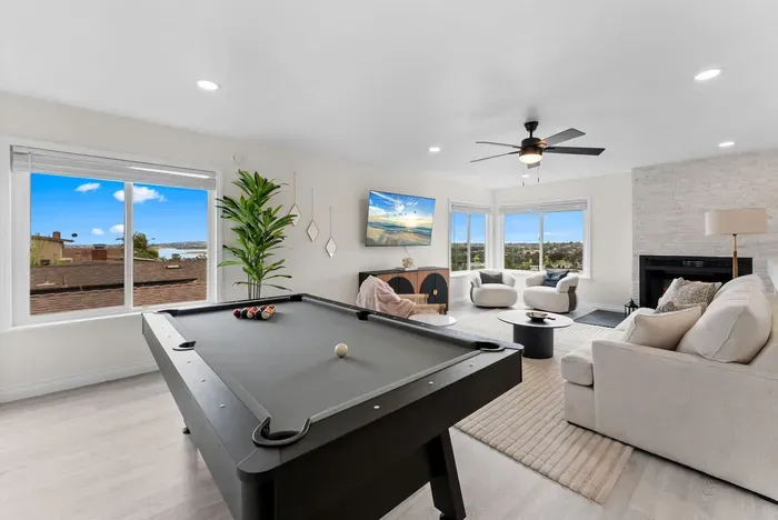 Bright lounge with pool table, fireplace & panoramic window views