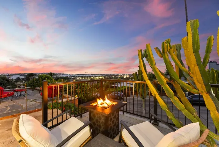Sunset bay-view terrace with cozy fire pit and plush seating.