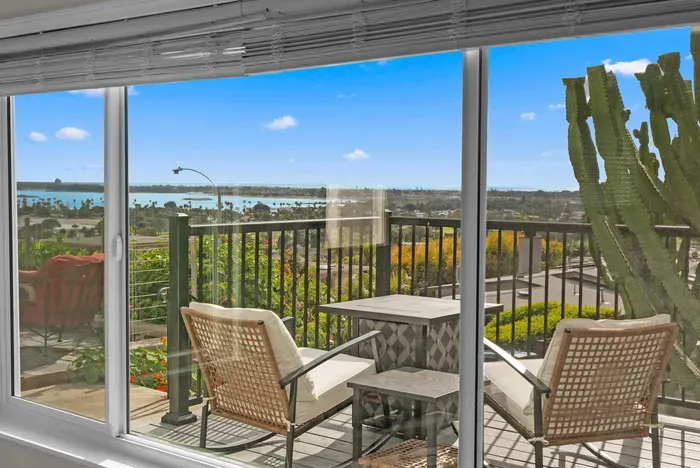Sunlit balcony with bay and city views—perfect for morning coffee