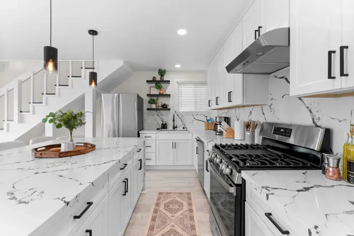 Modern chef's kitchen: quartz island, gas range, stainless appliances