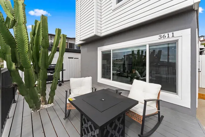 Sunny private deck with fire table, cushioned rockers and a grill.