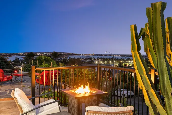Bay-view terrace with cozy fire pit, lounge seating, and city lights.