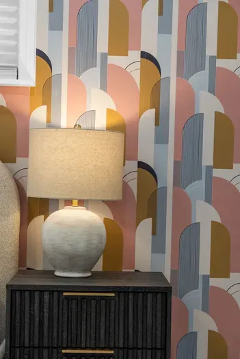 Stylish bedside nook with modern lamp, bold art deco wallpaper