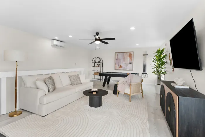 Bright lounge with pool table, big TV, and chic, comfy seating