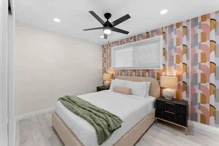 Cozy modern bedroom with statement wallpaper and luxe bedding