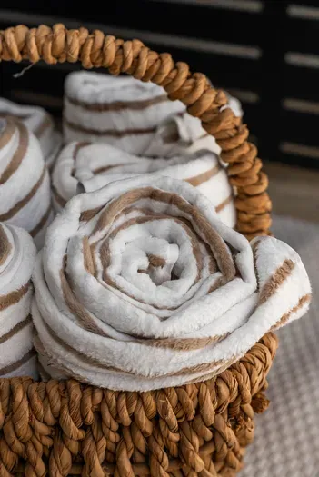 Plush striped towels in a woven basket—spa-like comfort awaits