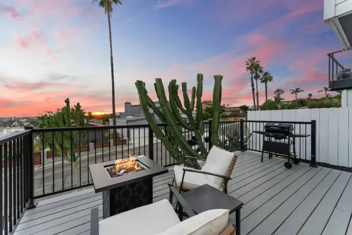 Sunset-view deck with fire pit, BBQ, and chic lounge seating.