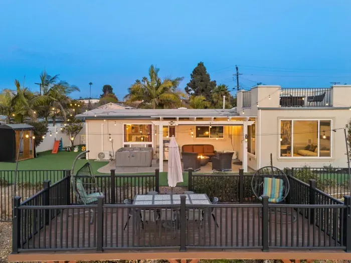 Spacious backyard oasis with cozy seating, a hot tub, and rooftop views!