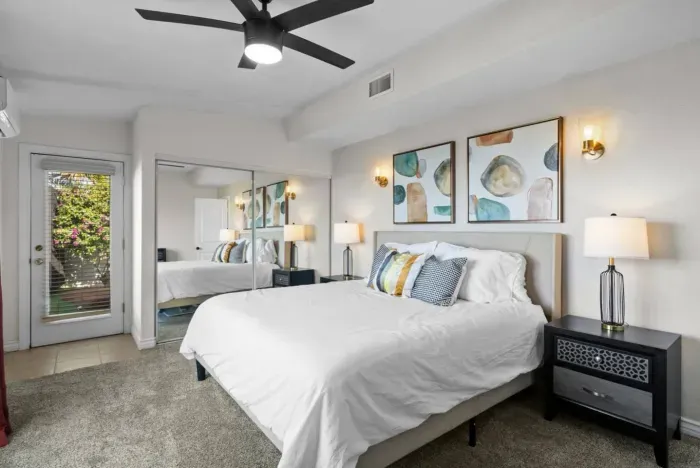 Serene and stylish bedroom with modern decor, cozy bedding, and a private outdoor entrance.
