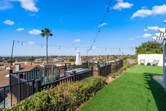 This beautifully designed backyard offers an elevated deck with sweeping views, lush greenery, and cozy seating areas—ideal for entertaining or relaxing!