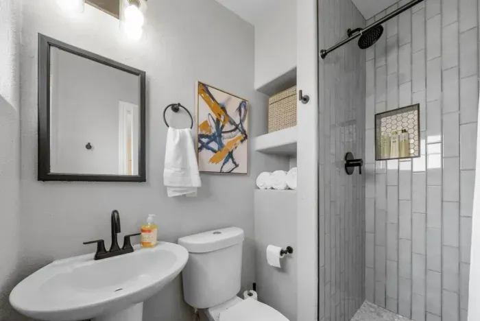 A stylish and modern bathroom with a walk-in shower and sleek black fixtures.
