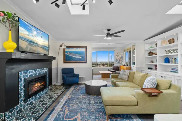 The living room features a smart TV, electric fireplace, and views to the outside