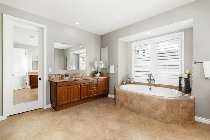 Primary bathroom attached to Bedroom 1 features two vanity areas, a shower and a soaking tub. (Please note that the closet is not accessible here, but there is an armoire and set of drawers in the bedroom for clothing storage)