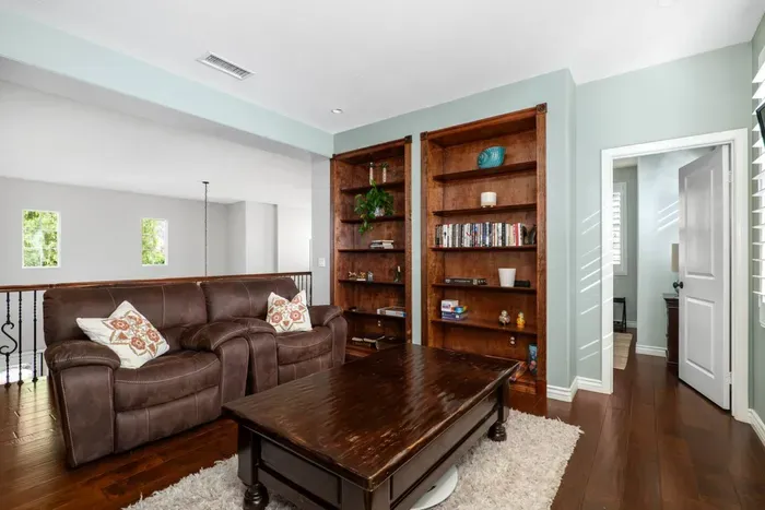 Upstairs living area with books, two club chairs and a TV