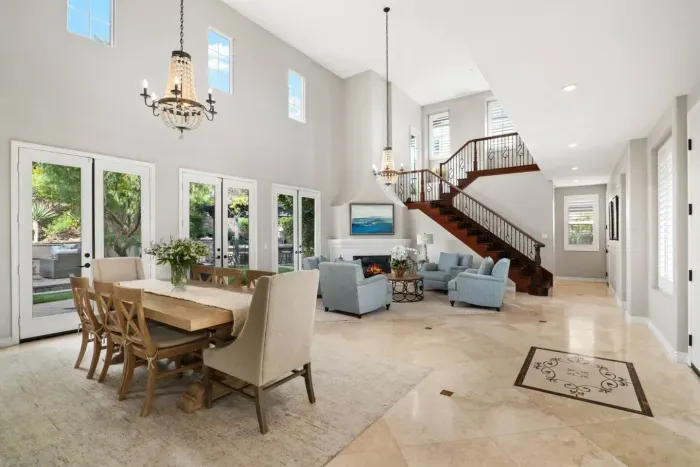 The grand entry area that includes a formal seating area and a second dining area for eight guests. Multiple french doors open to the back yard