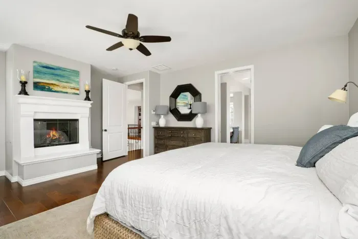 The spacious primary bedroom has a dresser and armoire for clothing storage