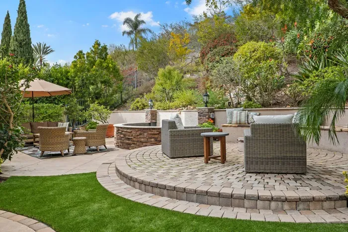 Backyard patio with a fire pit, water feature and two sitting areas