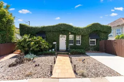 Exterior adorned with ivy and driveway parking available.