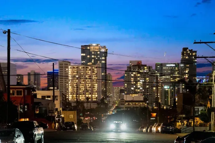 Glowing high-rises and a colorful sunset creating a lively urban scene.