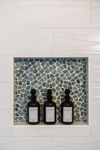 Mosaic tile shower niche with luxury bath essentials