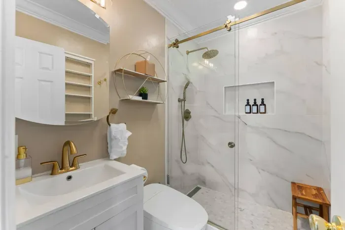 Spa-style bathroom with walk-in shower and gold fixtures
