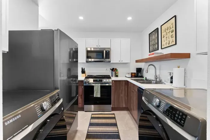 A sleek kitchen with walnut cabinets and stainless steel appliances.