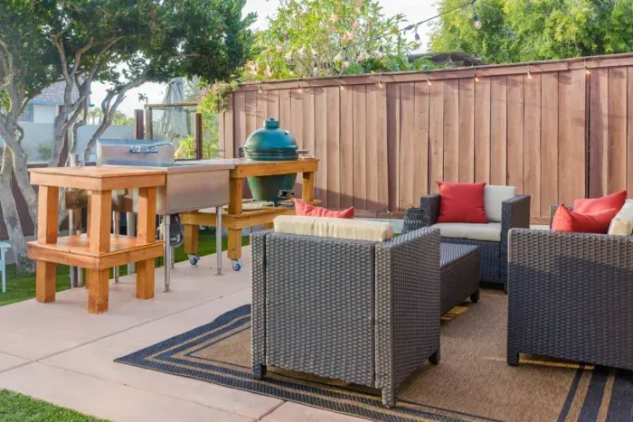 Outdoor lounge with comfy seating, BBQ grill, and relaxing backyard vibes.