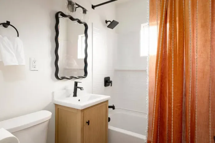 Refresh in the updated bathroom, featuring a statement mirror, modern fixtures, and a clean aesthetic.