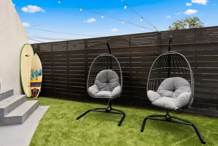 Backyard with hanging chairs and market lights