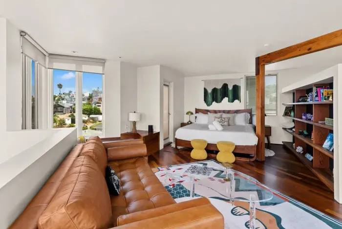 Spacious bedroom with plush seating and warm natural light