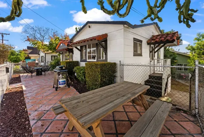 spacious patio with a picnic-style table and lush desert plants—great for outdoor dining or relaxing.