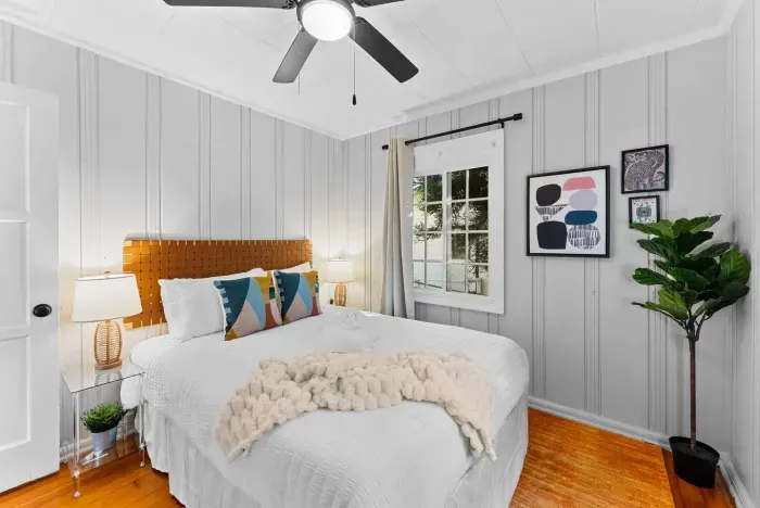 A second bedroom with a bold headboard and colorful throw pillows adding a modern design touch.