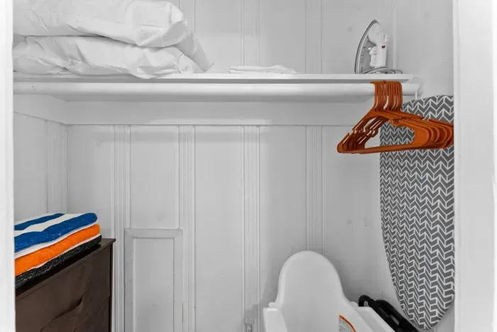 tidy closet area with hangers and extra linens ready for guest use.