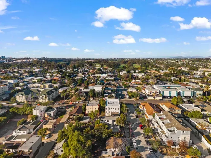 bright aerial view of the surrounding neighborhood on a clear day, revealing charming streets and tree-lined blocks.