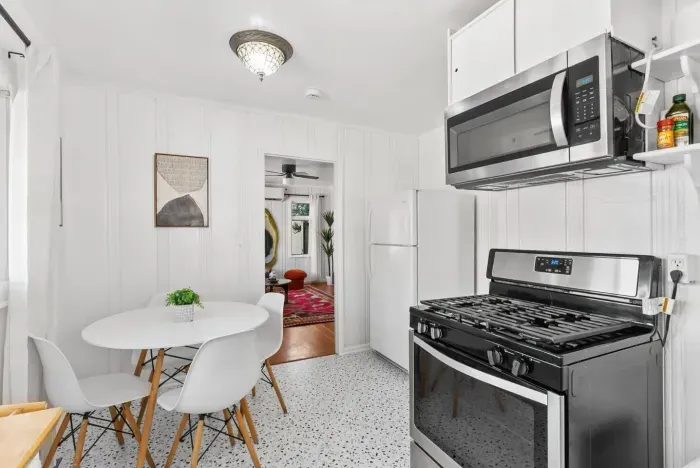 sleek, functional kitchen with a gas range and stainless-steel microwave, perfect for cooking at home.