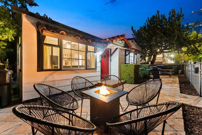 The charming outdoor patio features a modern fire pit surrounded by stylish seating—perfect for winding down under the evening sky.