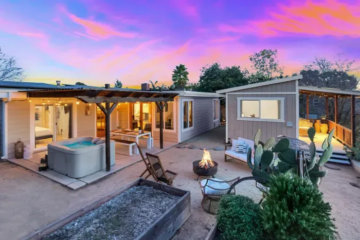 Your cozy desert escape—hot tub, fire pit, and sunset skies all around.