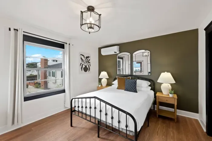 Serene bedroom with soft tones and city views just beyond.