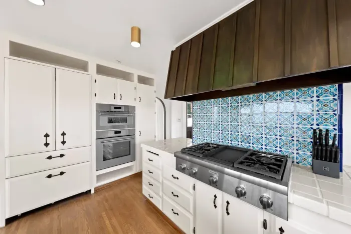 A stylish kitchen with brass accents and a pop of patterned tile.