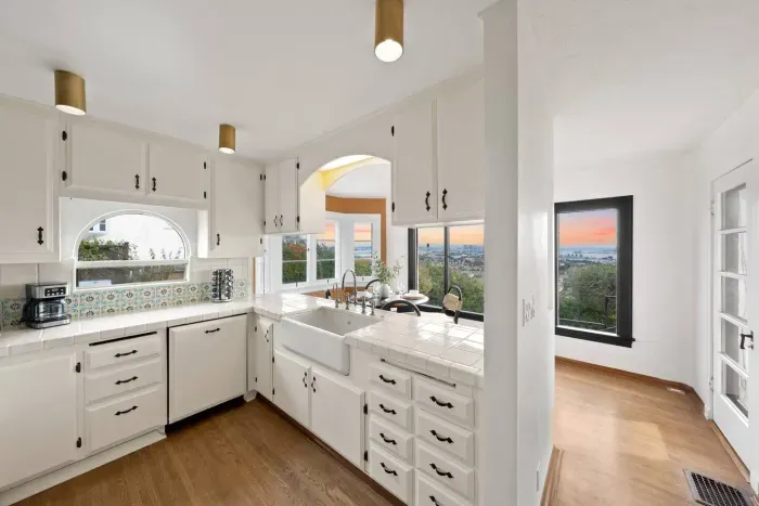 Sunlit kitchen framed by windows and ocean light.