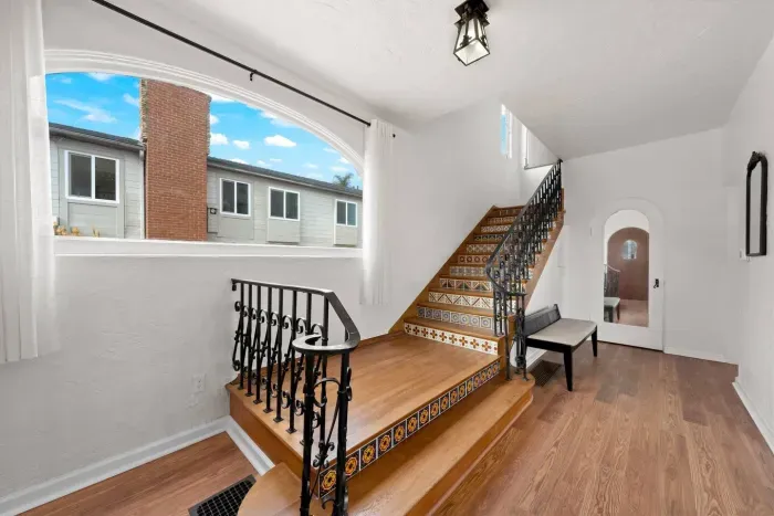 A graceful staircase welcomes you with sunlight and vintage charm — every detail designed to make your arrival feel special.